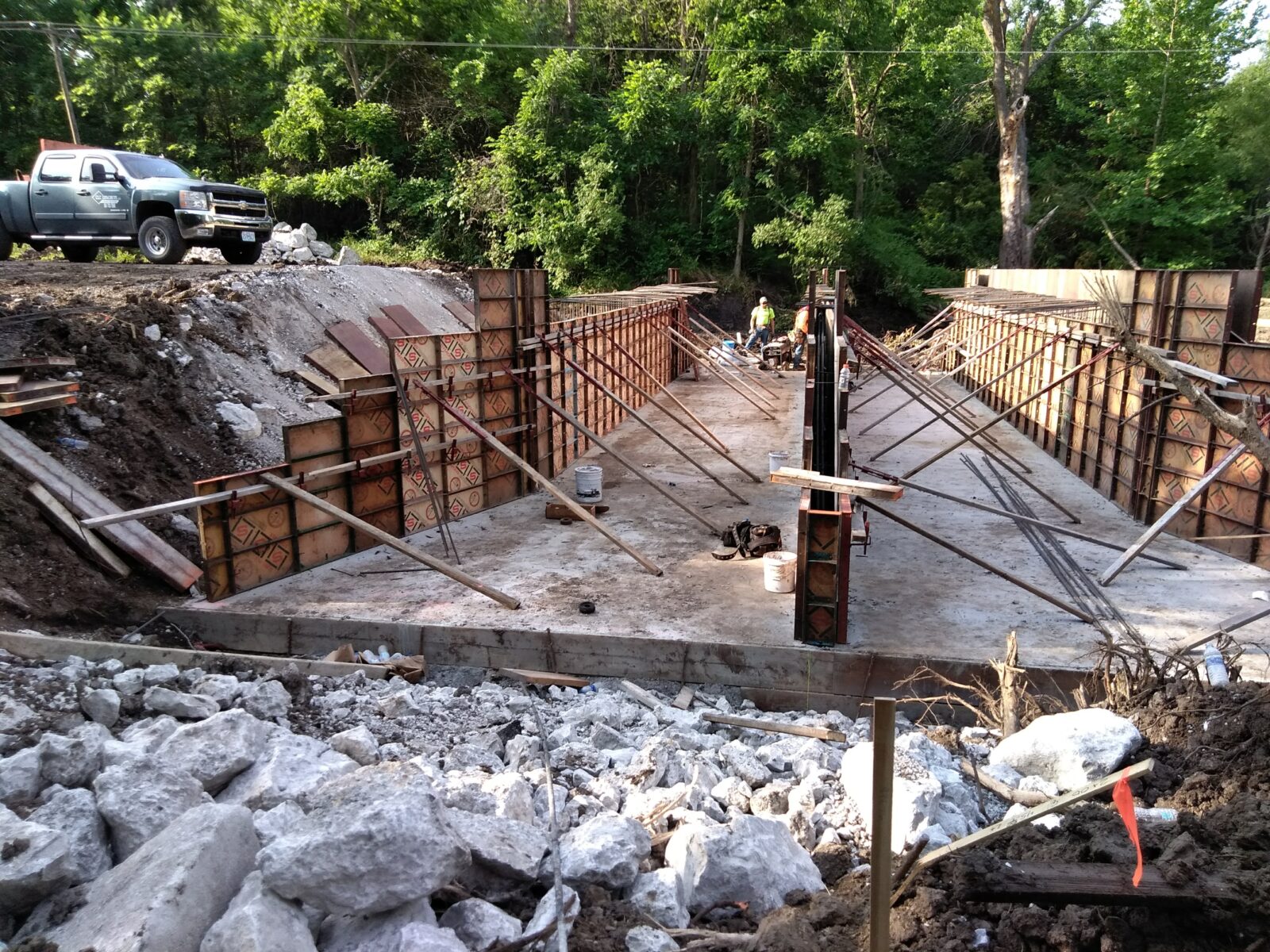 An image of an excavation under construction, with concrete on the bottom and temporary structures to retain the soil at the sides.