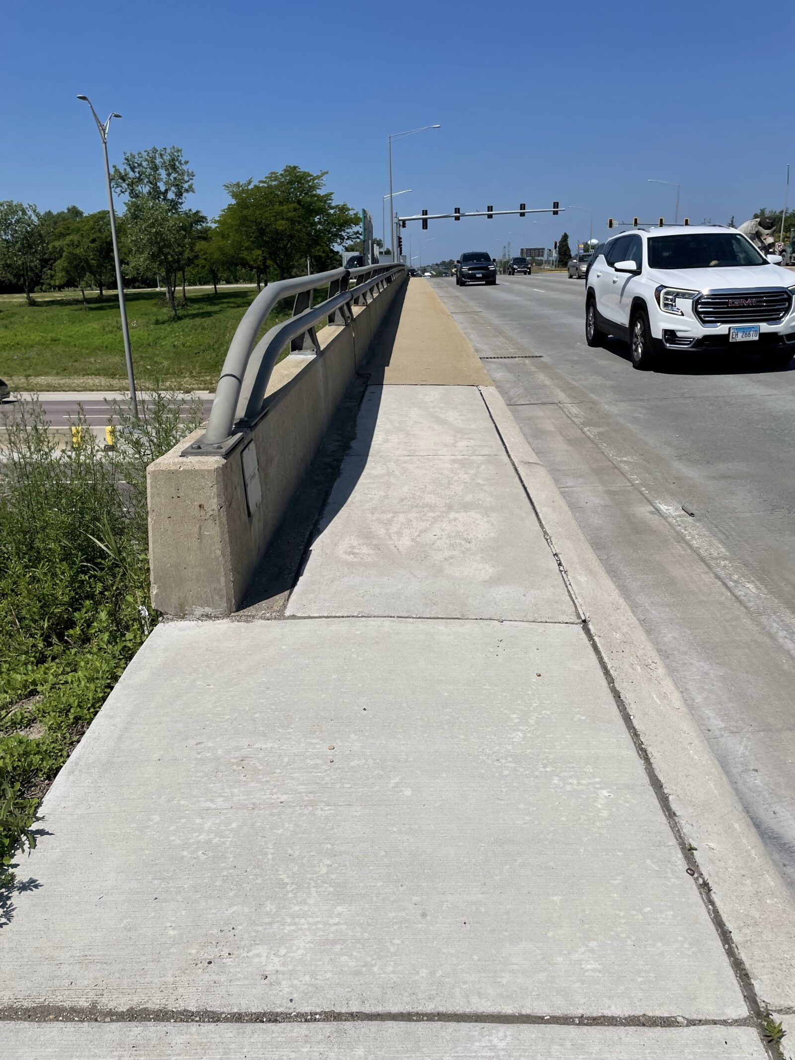 An image of the sidewalk on the side of a bridge.