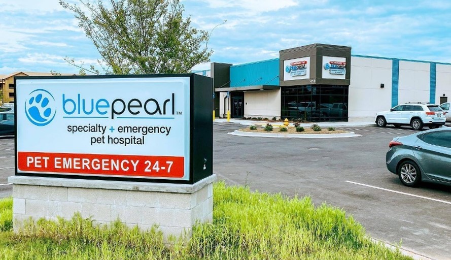 Image of a the bluepearl building taken from the parking lot, with a monument sign.