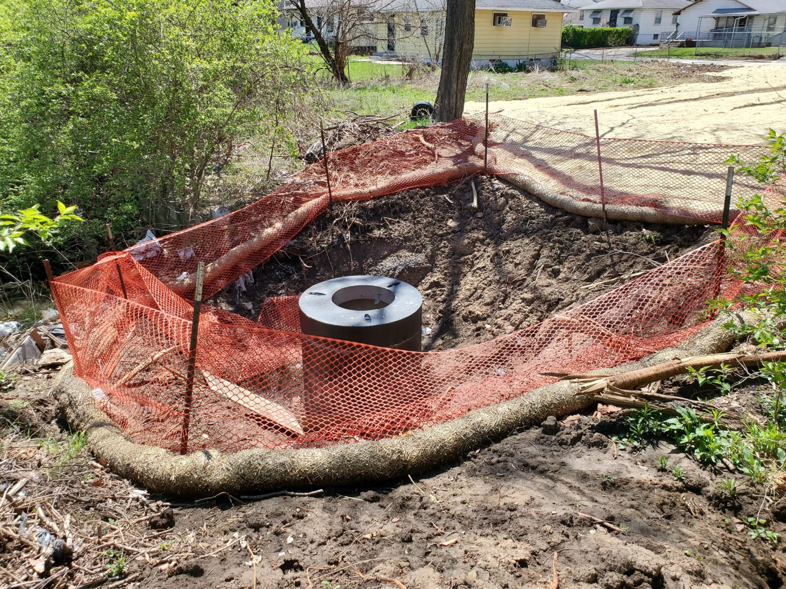 Image of a fenced off excavation with a pipe inside.
