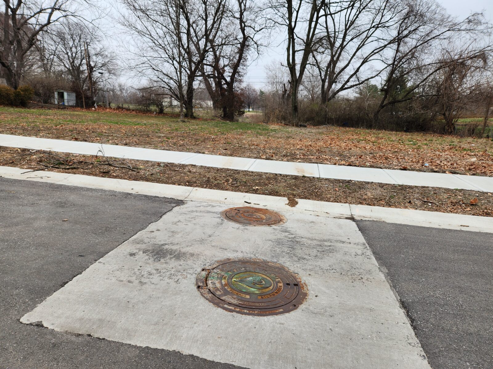 Image of a pavement patch with manholes in it.