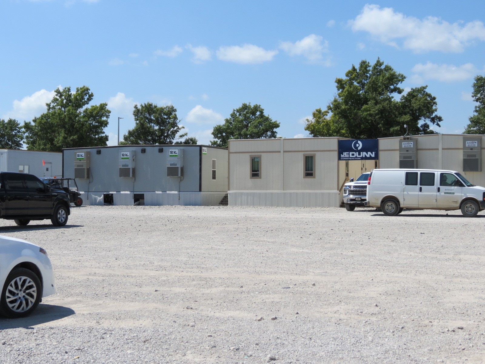 An image of a gravel parking lot, with logistics buildings in the background.