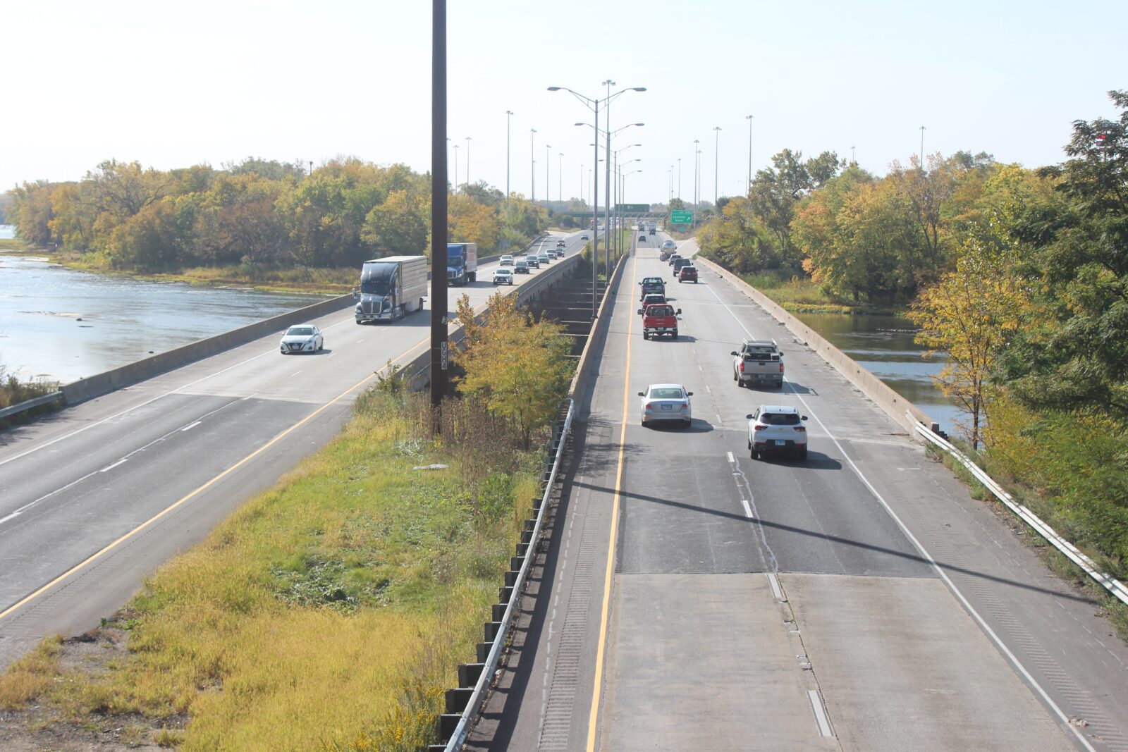 An image of a divided bridge over a river, with two lanes of traffic in each direction.